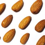 brown almond nuts on white background